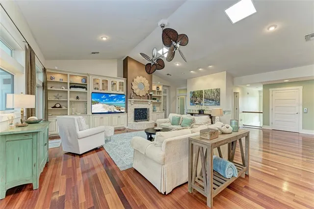 a view of a hallway with wooden floor and a bathroom