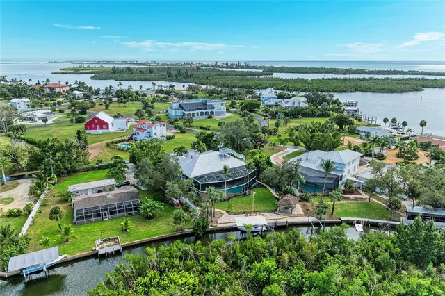 an aerial view of a city with lots of residential buildings ocean and mountain view in back