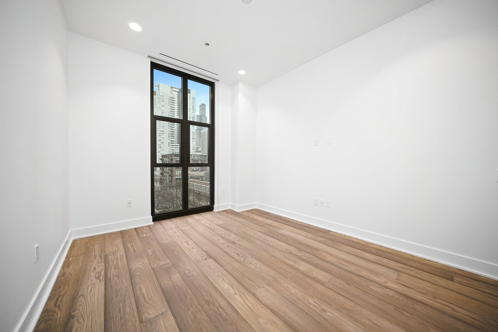 900 West Washington Boulevard, Unit 504 Chicago, IL 60607 - Photo 19 of 28 a view of an empty room with wooden floor and a window