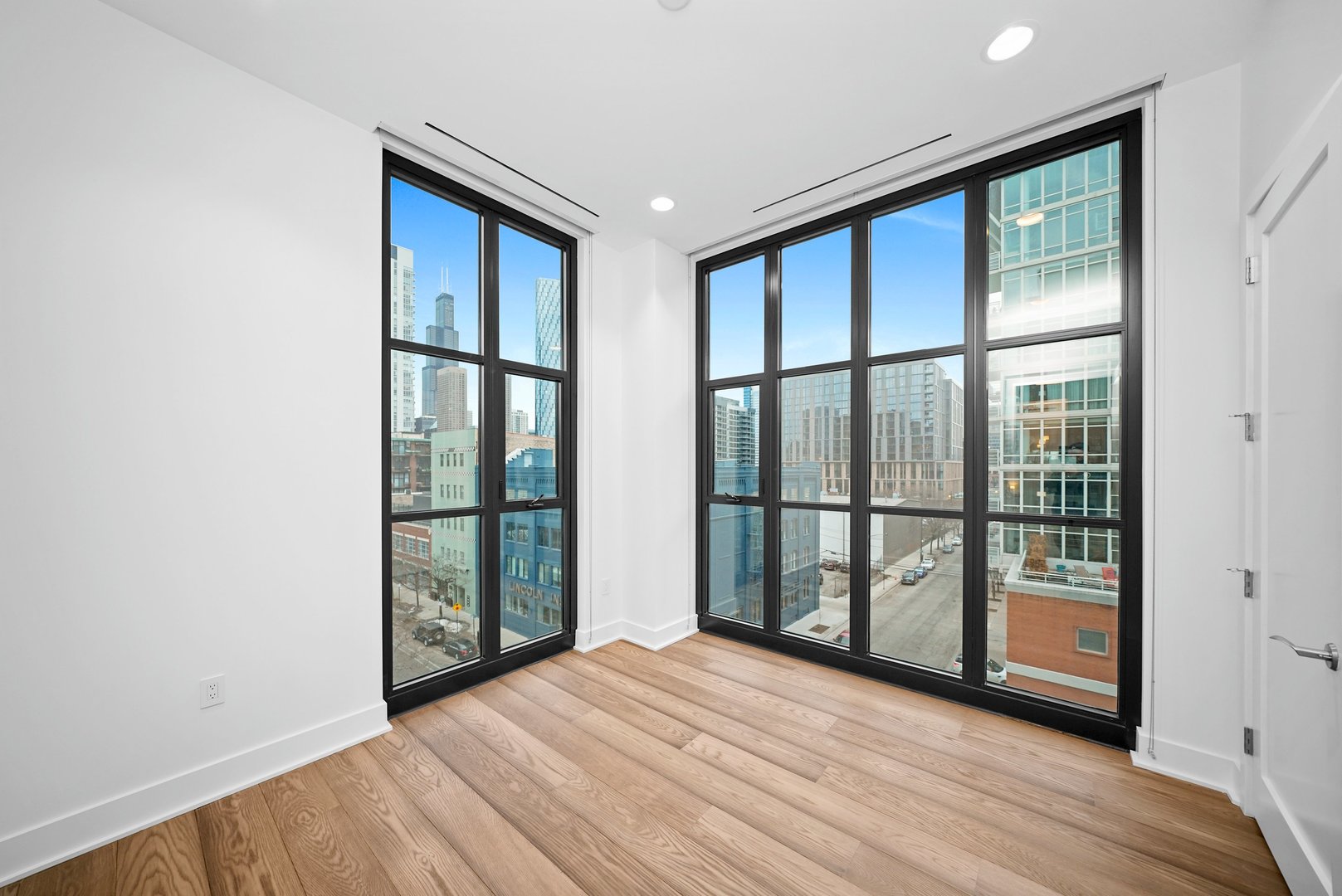 900 West Washington Boulevard, Unit 504 Chicago, IL 60607 - Photo 23 of 28 a view of an empty room with wooden floor and a window