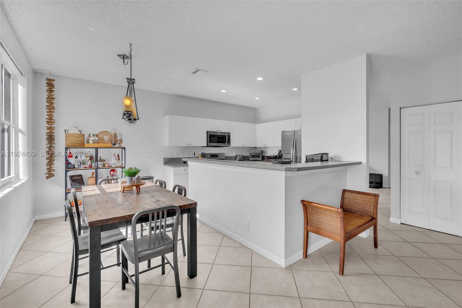 1058 Tupelo Way Weston, FL 33327 - Photo 11 of 43 a kitchen with a dining table chairs and white cabinets