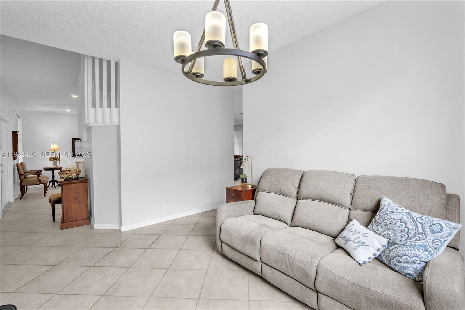1058 Tupelo Way Weston, FL 33327 - Photo 19 of 43 a living room with furniture and a chandelier