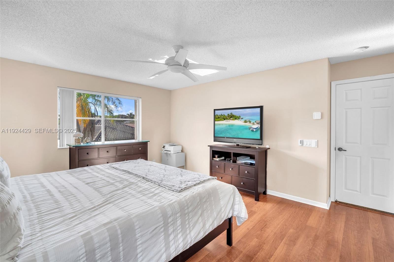 1058 Tupelo Way Weston, FL 33327 - Photo 24 of 43 a bedroom with a bed and a flat screen tv