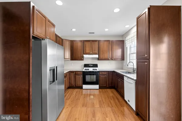 a kitchen with stainless steel appliances granite countertop a sink and a refrigerator