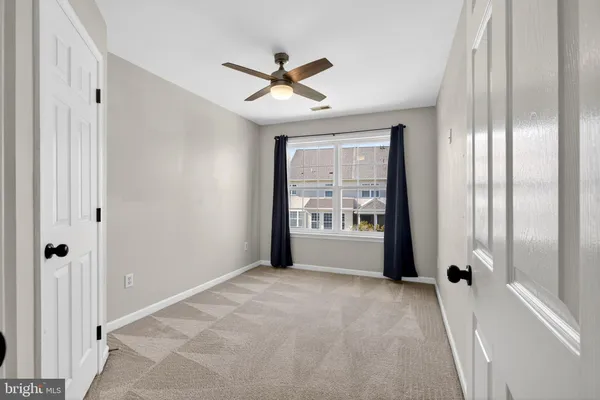 a view of a hallway with windows and chandelier fan