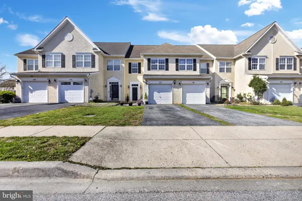 a front view of a house with a garden and yard