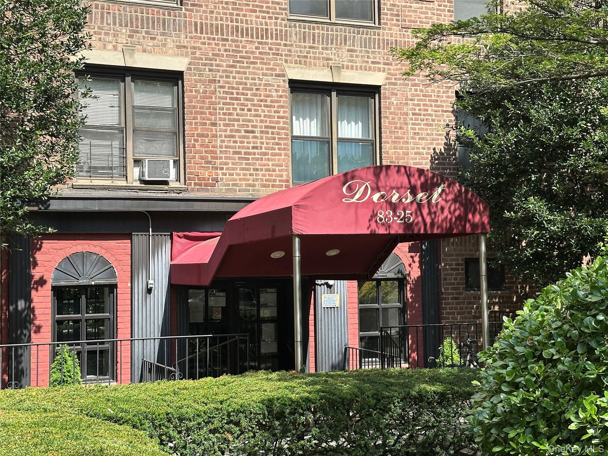 83-25 98th Street, Unit 4T Queens, NY 11421 - Photo 2 of 10 a view of brick building with a large window and a large tree
