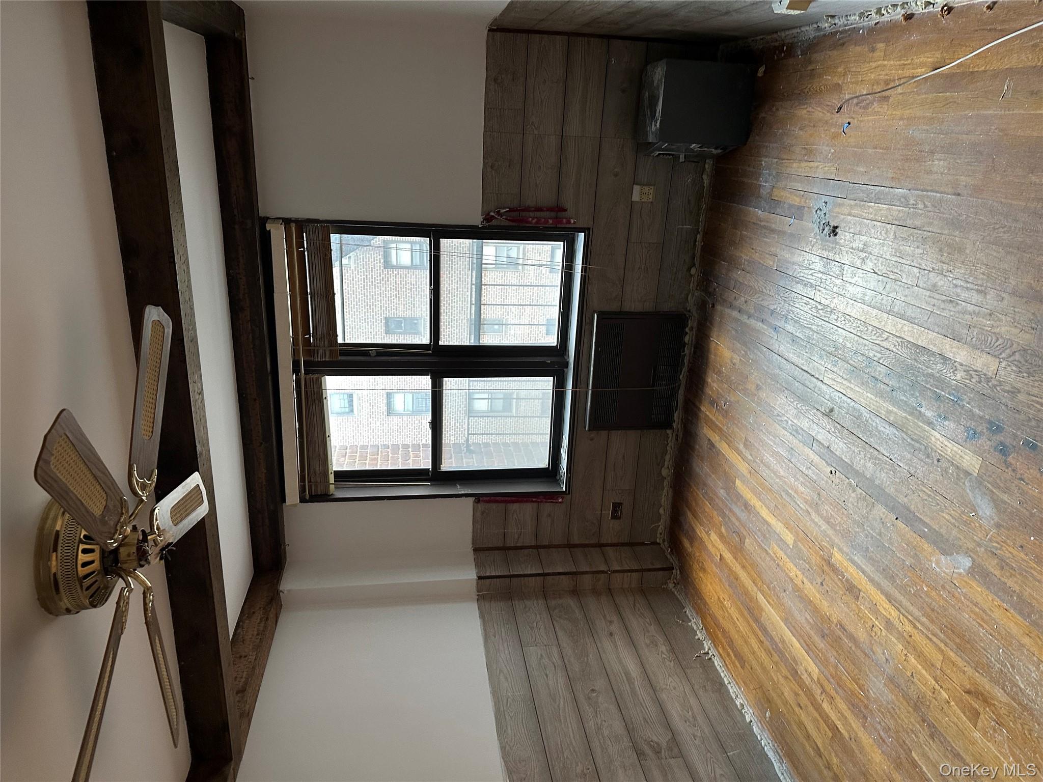 83-25 98th Street, Unit 4T Queens, NY 11421 - Photo 9 of 10 a view of an empty room with a window and wooden floor