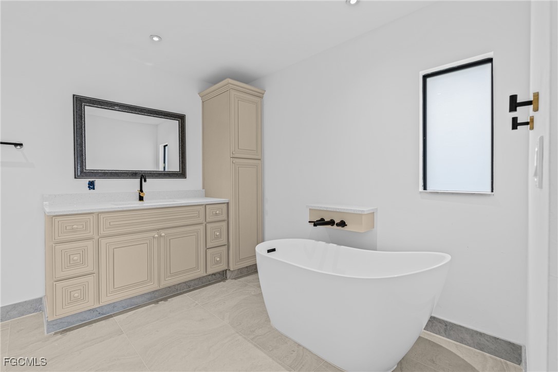 3310 3rd Street Southwest Lehigh Acres, FL 33976 - Photo 17 of 23 a bathroom with a bathtub sink and mirror