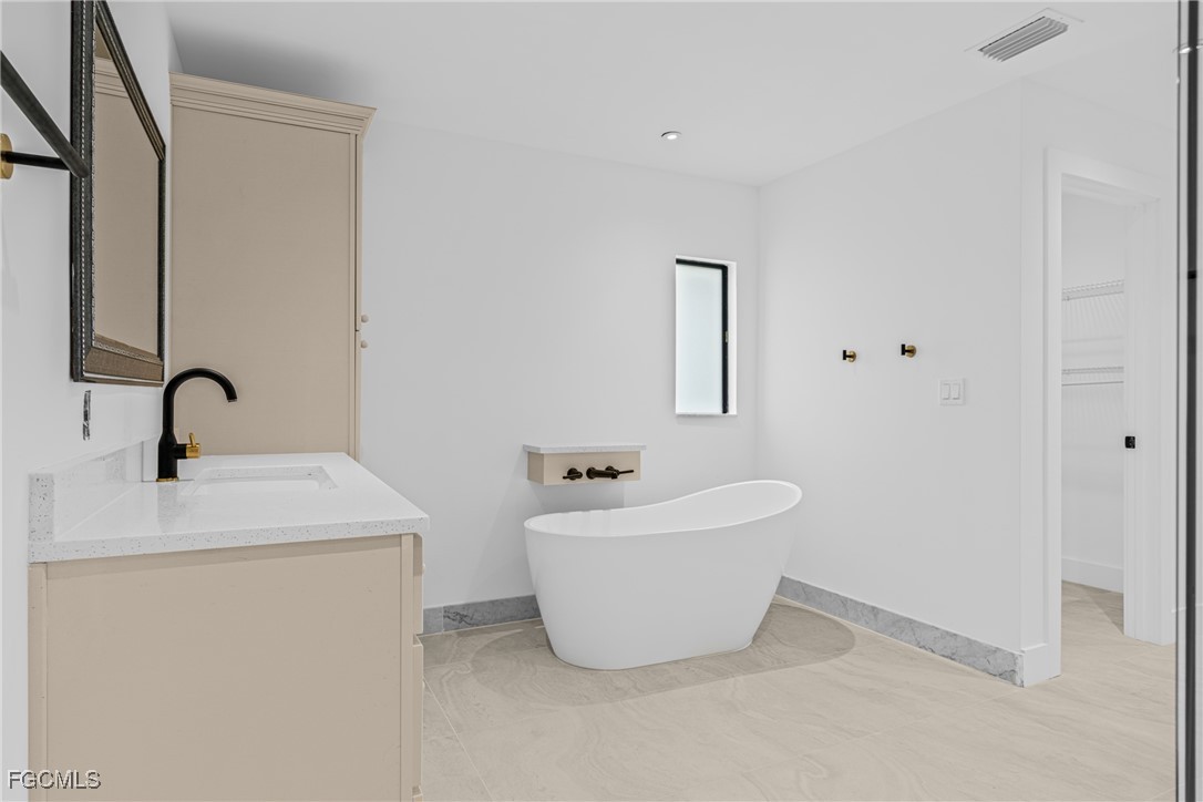 3310 3rd Street Southwest Lehigh Acres, FL 33976 - Photo 19 of 23 a bathroom with a sink and mirror