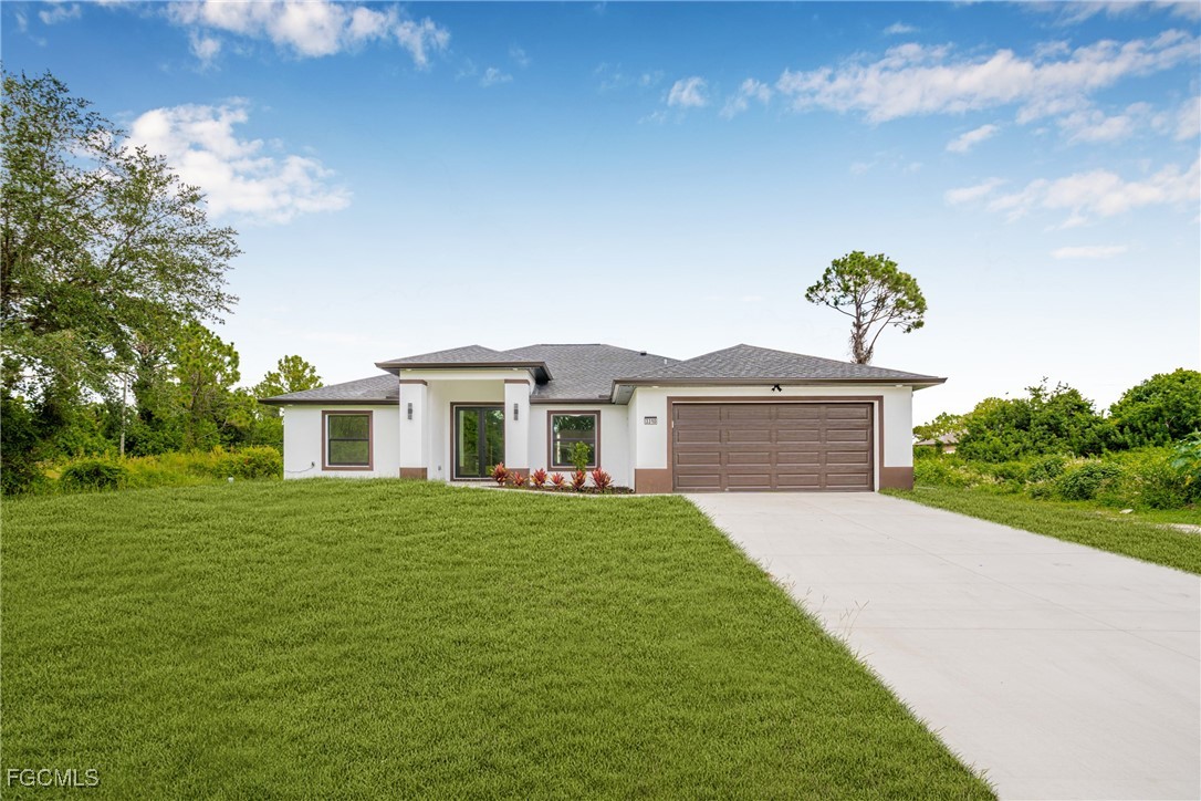 3310 3rd Street Southwest Lehigh Acres, FL 33976 - Photo 2 of 23 a front view of a house with a garden