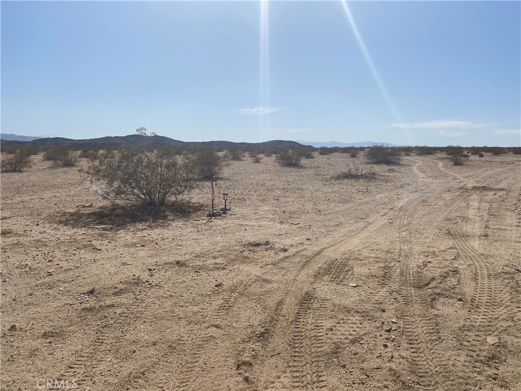 0 Windsong Joshua Tree, CA 92252 - Photo 2 of 6 a view of a dry yard with mountains in the background