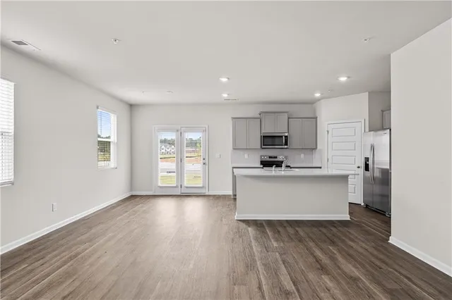 a kitchen with a sink a stove a refrigerator and white cabinets