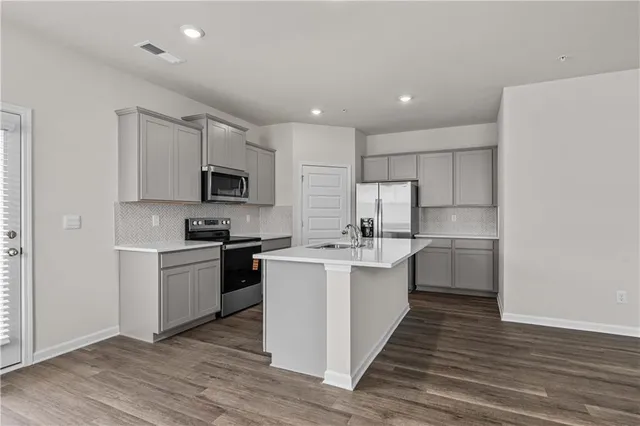 a kitchen with stainless steel appliances a sink stove and cabinets