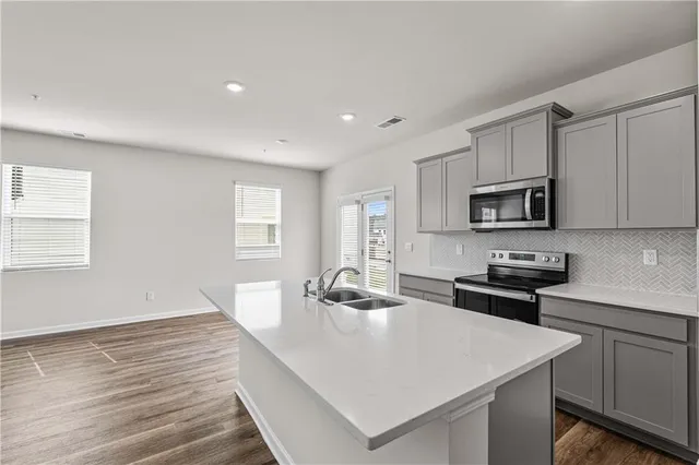 a view of kitchen with wooden floor and electronic appliances