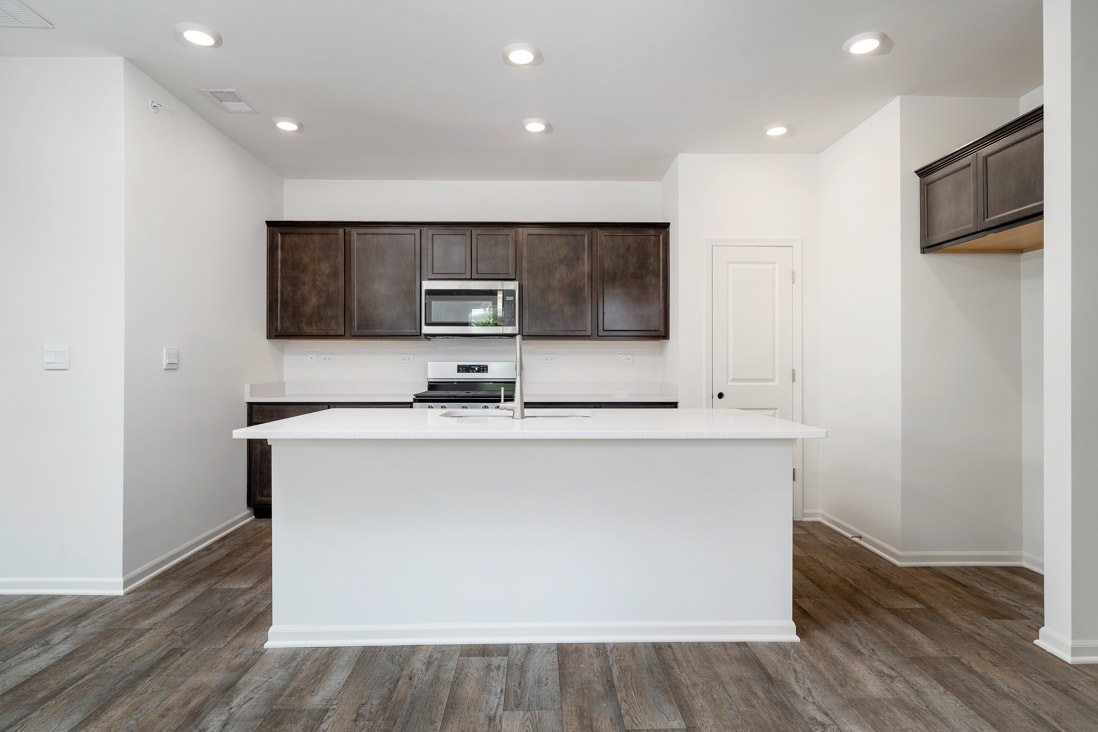 929 Darwin Street North Aurora, IL 60542 - Photo 5 of 42 a large kitchen with stainless steel appliances a large counter top a stove a microwave a sink and a refrigerator