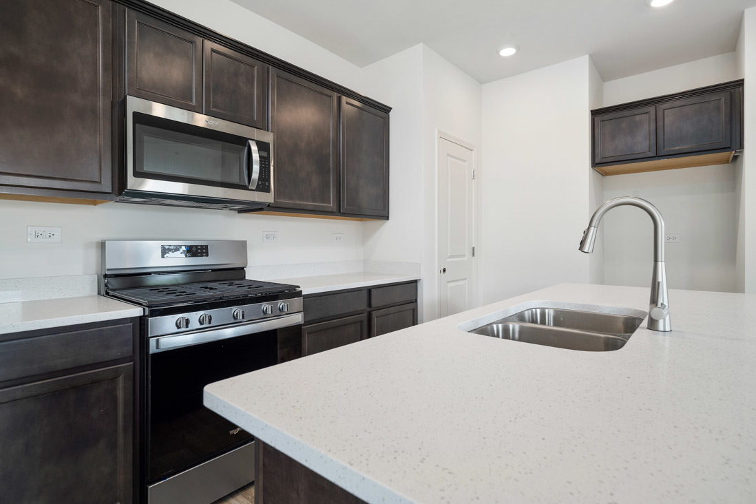 929 Darwin Street North Aurora, IL 60542 - Photo 7 of 42 a kitchen with stainless steel appliances a stove a sink a microwave and cabinets