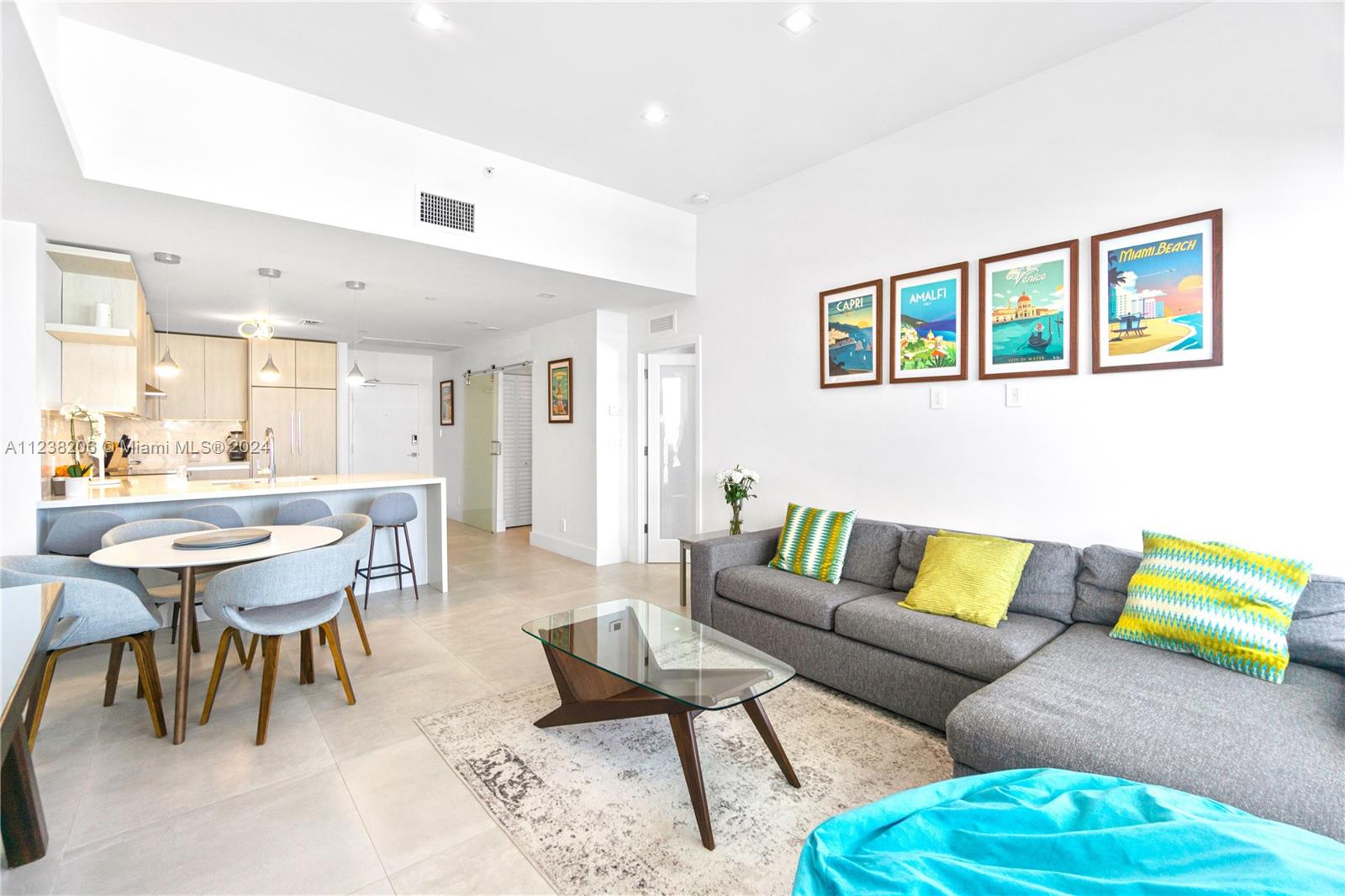 a living room with a couch and kitchen view