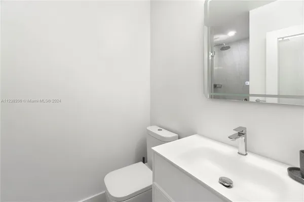 a bathroom with a sink a toilet and mirror