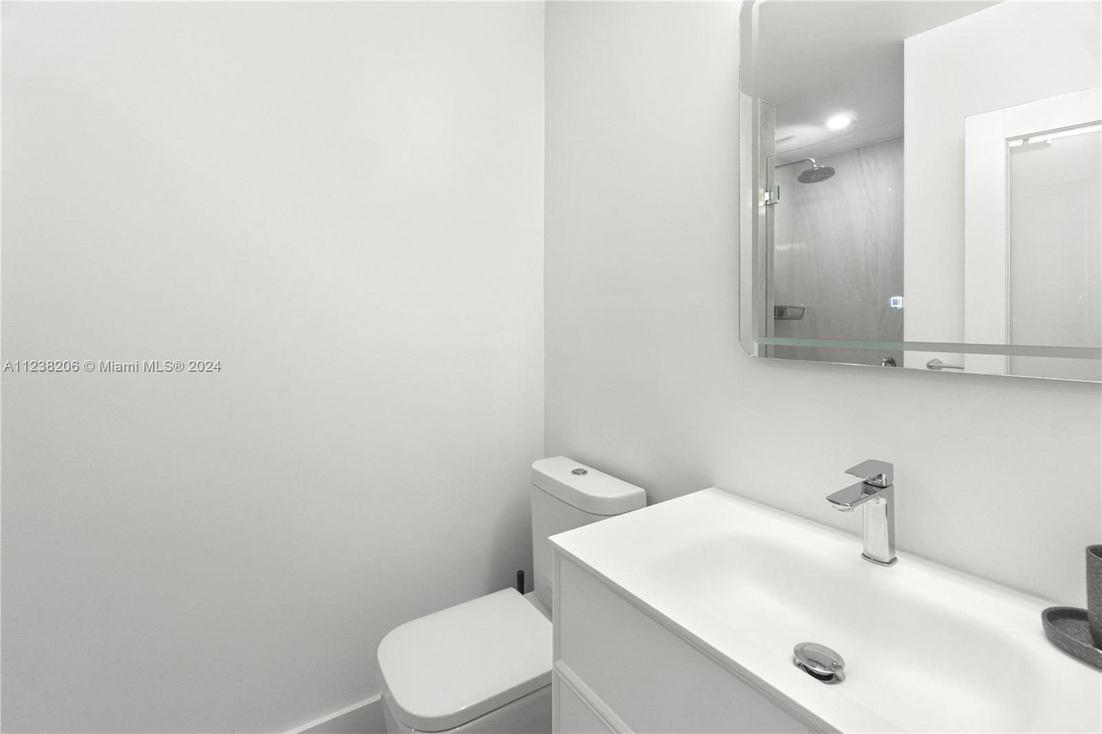 100 Lincoln Road, Unit 1608 Miami Beach, FL 33139 - Photo 13 of 22 a bathroom with a sink a toilet and mirror