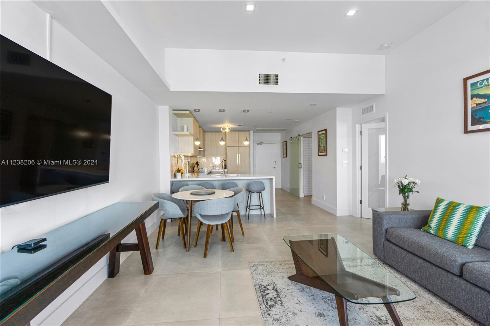 100 Lincoln Road, Unit 1608 Miami Beach, FL 33139 - Photo 3 of 22 a living room with furniture a flat screen tv and kitchen view