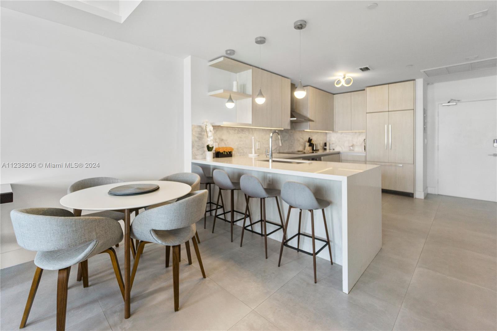 100 Lincoln Road, Unit 1608 Miami Beach, FL 33139 - Photo 5 of 22 a kitchen with kitchen island a dining table and chairs