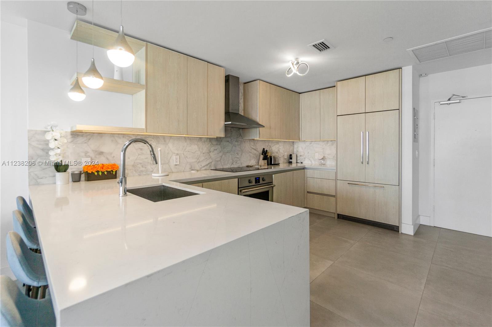 100 Lincoln Road, Unit 1608 Miami Beach, FL 33139 - Photo 8 of 22 a kitchen that has a lot of white cabinets and stainless steel appliances