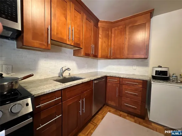 a kitchen with stainless steel appliances granite countertop a sink stove and microwave