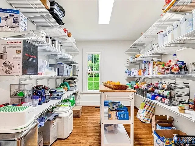 a room with lots of books and white cabinets