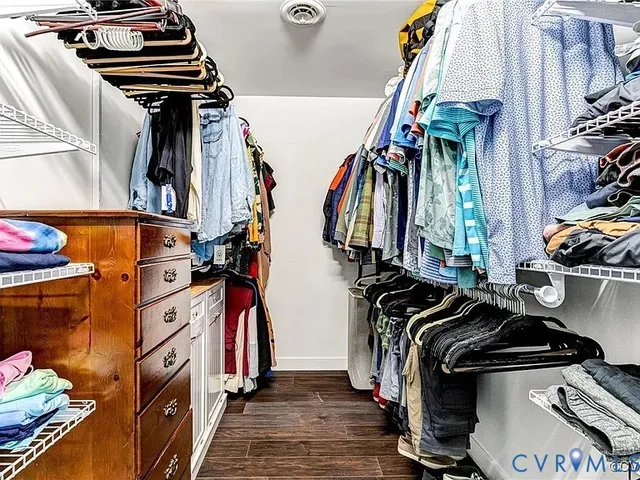a view of walk in closet with clothes and shoes