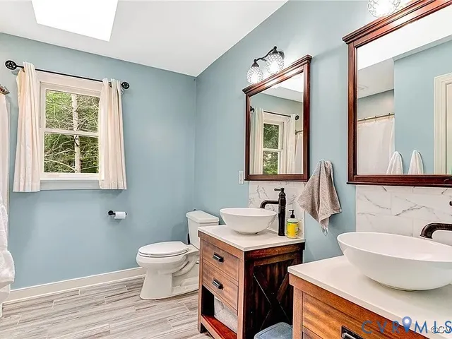 a bathroom with a toilet a sink and a mirror