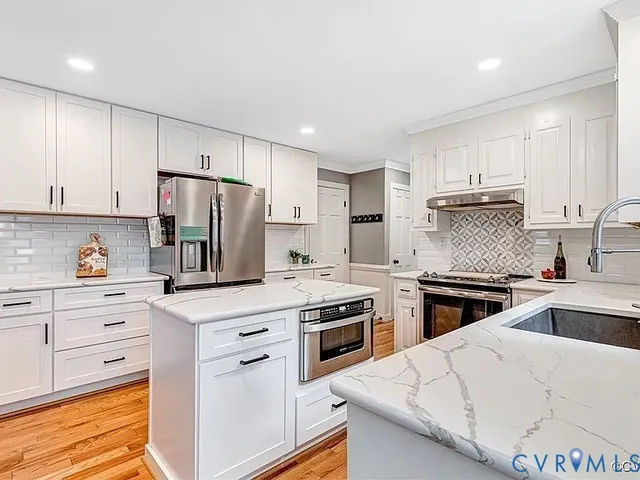 a kitchen with white cabinets and stainless steel appliances