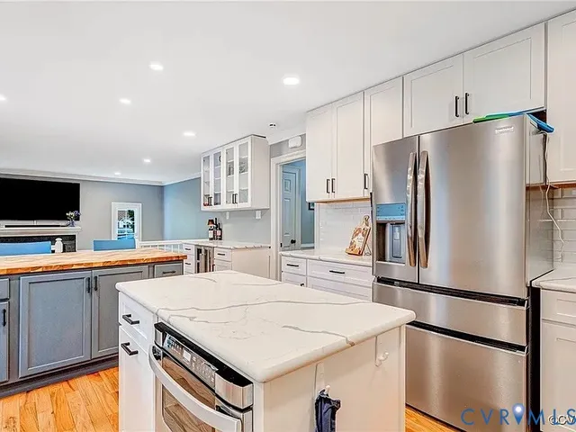 a kitchen with stainless steel appliances a refrigerator and a stove top oven