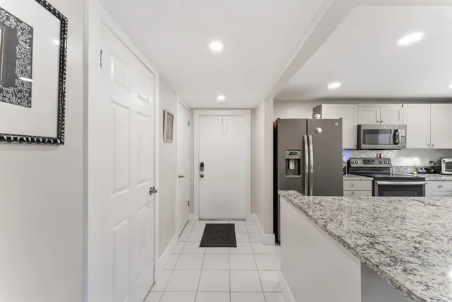 a kitchen with stainless steel appliances granite countertop a refrigerator and a sink