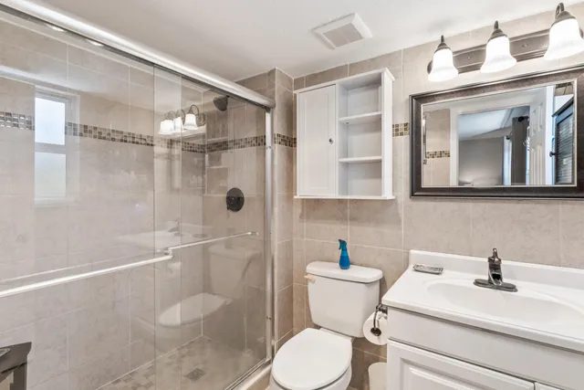 a bathroom with a sink a toilet and shower