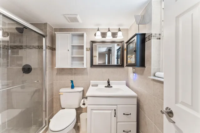 a bathroom with a sink a toilet and shower