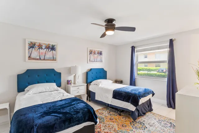 a bedroom with 2 bed and a window