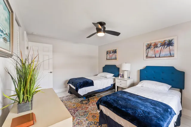 a spacious bedroom with two beds and potted plant