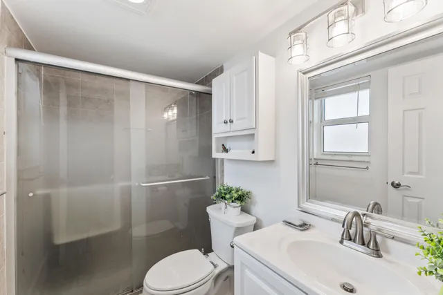 a bathroom with a sink toilet and shower