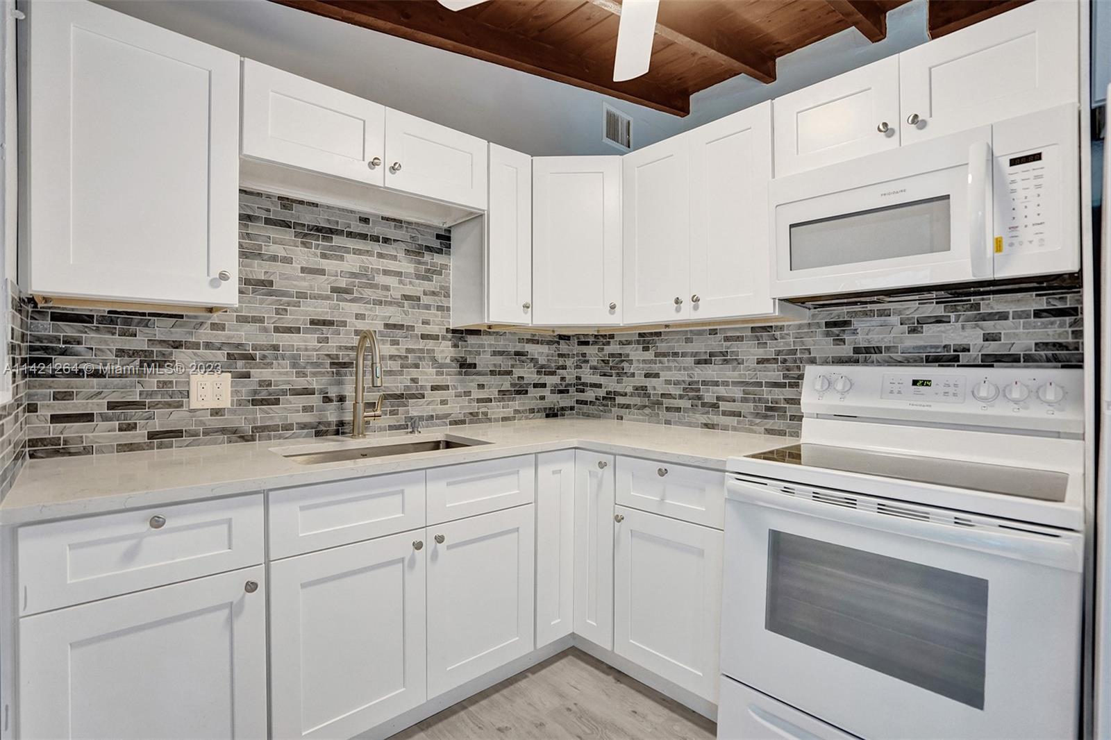 434 Southwest 22nd Terrace Fort Lauderdale, FL 33312 - Photo 4 of 15 a kitchen with white cabinets stainless steel appliances and sink