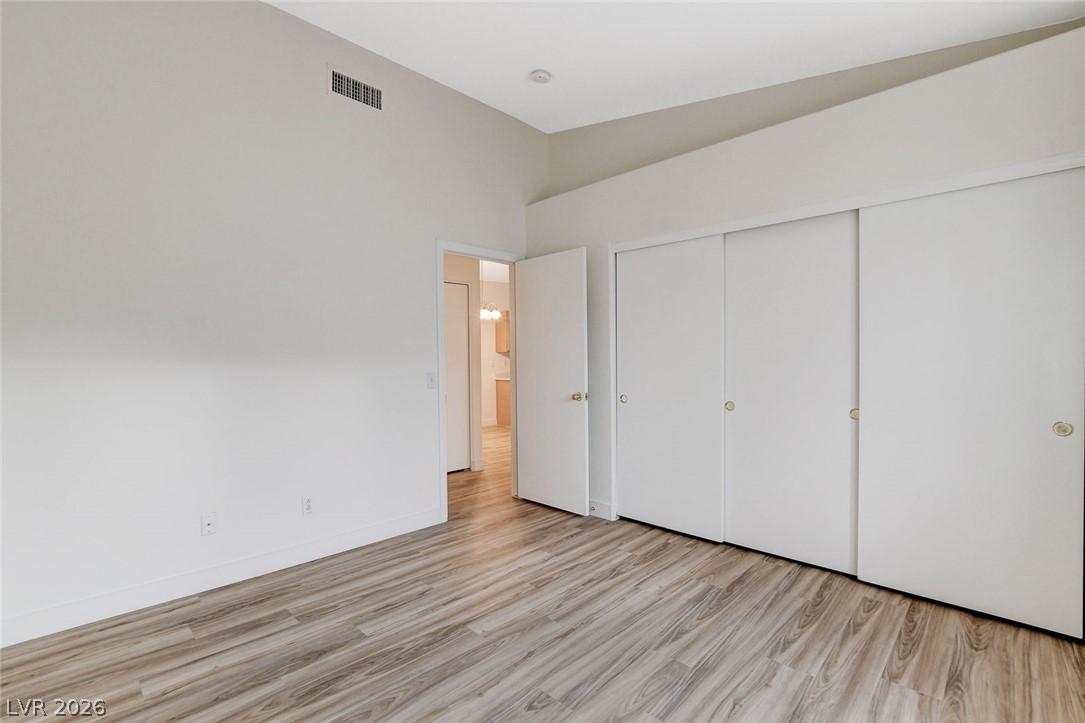 2052 Quarry Ridge Street, Unit 201 Las Vegas, NV 89117 - Photo 13 of 25 An airy bedroom with wood flooring and convenient closet storage.