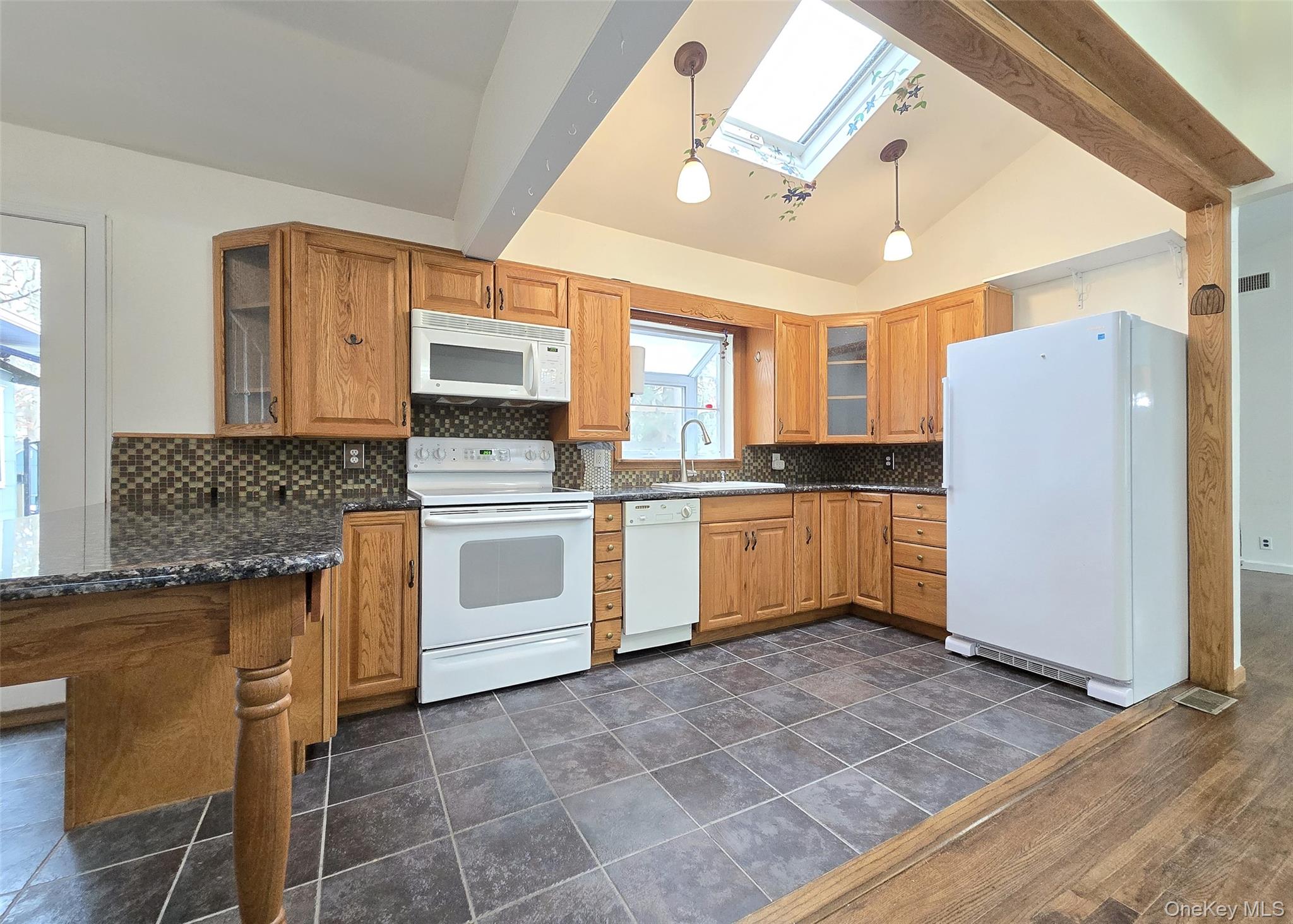27 Forest Trail Ridge, NY 11961 - Photo 7 of 29 L-Shaped Granite Counter W/Room For Bar Seating, Unique Backsplash, Drop Lighting, Atrium Window, 1Yr Old Fridge, & Skylight