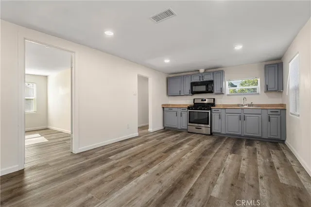 a view of kitchen with wooden floor electronic appliances and window