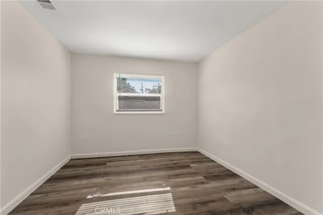 a view of a room with wooden floor and window