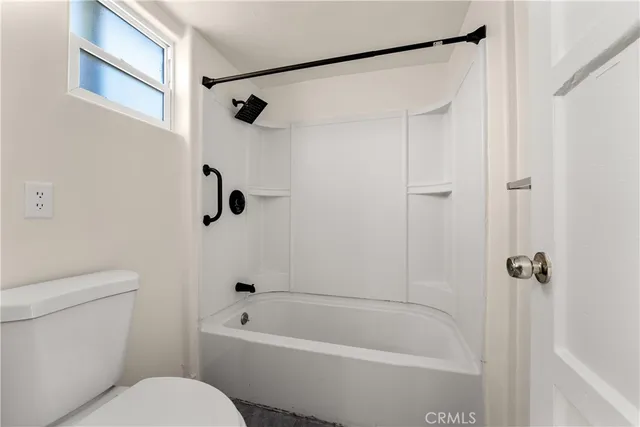a bathroom with a toilet and a shower