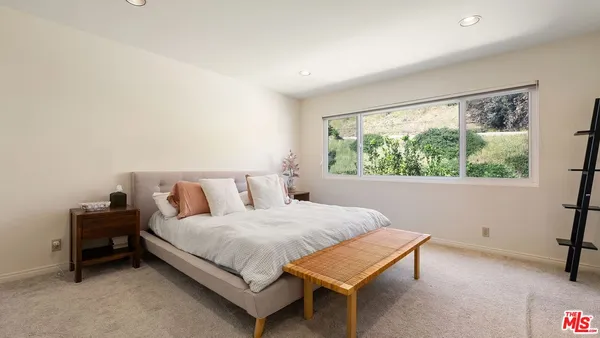 a bedroom with a bed table and a window
