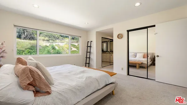 a bedroom with a bed and a large window