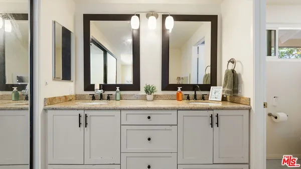 a bathroom with double sink and a mirror