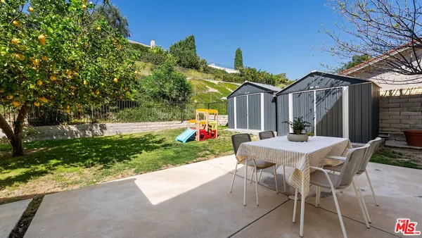 a view of a house with backyard and sitting area
