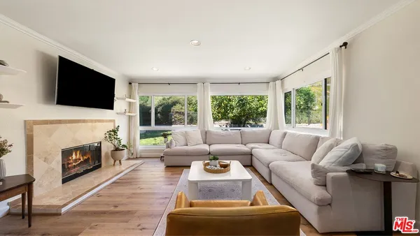 a living room with furniture a fireplace and a flat screen tv